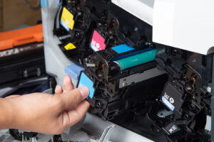 Man checking and changing the printer cartridges of multi-function printer in office